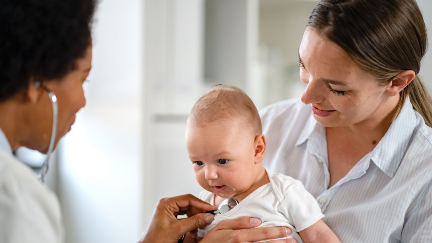 Adult holding child getting an exam